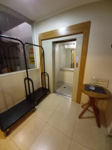 um quarto com um corredor com uma mesa e uma porta em Hotel Flat Alameda em Araçatuba