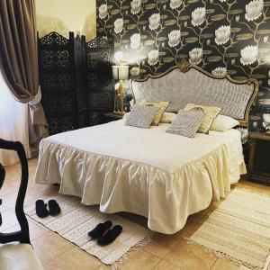 a bedroom with a bed with white sheets and black and white wallpaper at Podere Sotto il cielo di Toscana casa vacanze con 5 monolocali indipendenti 2 bungalowe nell uliveto piscina parcheggio Only adults Pet friendly in Camaiore