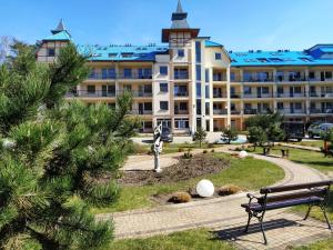 un gran edificio con un banco delante en Sunrise Blue Mare, en Łukęcin