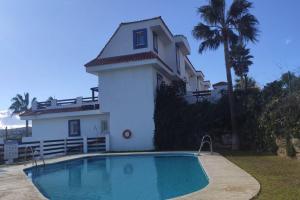 ein Haus mit einem Swimmingpool vor einem Haus in der Unterkunft ESPAGNE, MANILVA, ANDALOUSIE , PENTHOUSE VUE MER 7 PERSONNES in Manilva