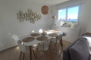 ein weißes Esszimmer mit einem weißen Tisch und Stühlen in der Unterkunft ESPAGNE, MANILVA, ANDALOUSIE , PENTHOUSE VUE MER 7 PERSONNES in Manilva