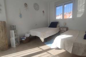 ein Schlafzimmer mit zwei Betten und einem Fenster in der Unterkunft ESPAGNE, MANILVA, ANDALOUSIE , PENTHOUSE VUE MER 7 PERSONNES in Manilva