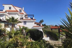 ein weißes Gebäude mit Palmen davor in der Unterkunft ESPAGNE, MANILVA, ANDALOUSIE , PENTHOUSE VUE MER 7 PERSONNES in Manilva