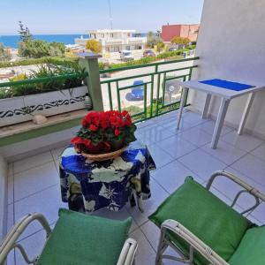 einen Balkon mit einem Tisch und einer Schüssel Blumen darauf in der Unterkunft Il Gabbiano casa al mare in Bisceglie