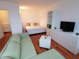 sala de estar con sofá y TV en Golden Family Apartments, en Praga