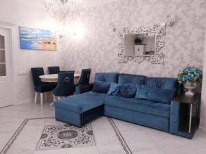 a living room with a blue couch and a table at Luxury Apartment on Krymskaya 22 in Gelendzhik