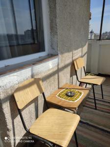 two chairs and a table on a balcony at Apartment Farmec in Cluj-Napoca
