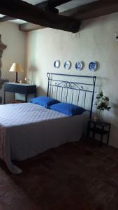 1 dormitorio con 1 cama con placas azules en la pared en Residenza Monastero de' Medici, en Bolsena