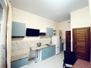 a kitchen with blue cabinets and a white refrigerator at 1-линия Апартаменты in Gelendzhik