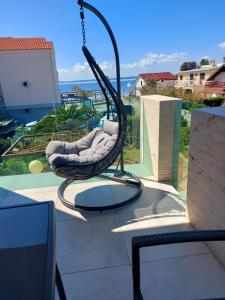 a swing on a patio with a view of the ocean at Apartments 4you in Vir