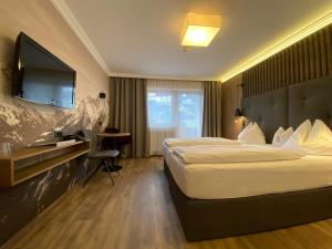 pokój hotelowy z łóżkiem i telewizorem w obiekcie Hotel Eder w mieście Ramsau im Zillertal