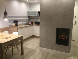 a kitchen with a fireplace in the middle of a room at Apartament Morski in Międzywodzie