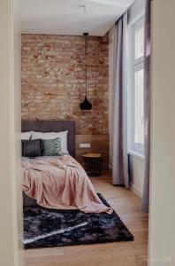 - une chambre avec un mur en briques et un lit dans l'établissement Apartament LUX Cieplice, à Jelenia Góra