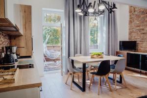 - une cuisine et une salle à manger avec une table et des chaises dans l'établissement Apartament LUX Cieplice, à Jelenia Góra