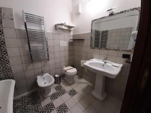 bagno con lavandino, servizi igienici e specchio di Agorà Panoramic Rooms a Sciacca