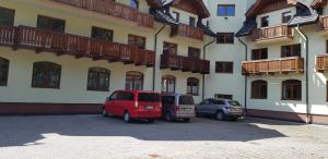 two cars parked in a parking lot in front of a building at AD Kamzík Donovaly in Donovaly