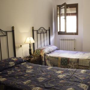 a bedroom with two beds and a lamp and a window at Casa Rural San Marcos in Yeste