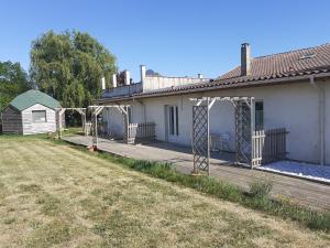 a house with a wooden deck in a yard at La Corraliere Chambres d'Hôtes in Nègrepelisse