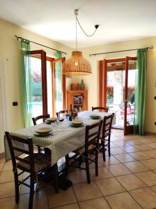 a dining room table with chairs and a chandelier at Villa Betulla con piscina privata sul lago di Como in Colico