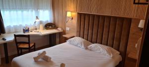 een hotelkamer met een bed, een bureau en een stoel bij The Originals Access, Hôtel Foix (P'tit Dej-Hotel) in Foix