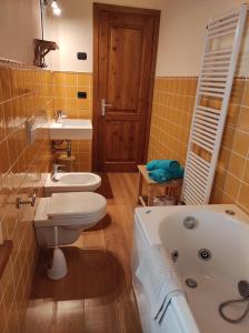 a bathroom with a tub and a toilet and a sink at Villa Betulla con piscina privata sul lago di Como in Colico +10 photos