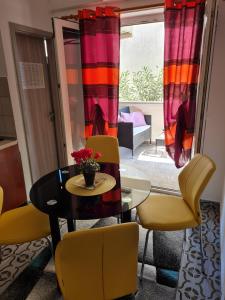 comedor con mesa y sillas amarillas en Apartments Dorotea en Novalja