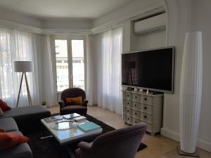 Appartement Centre ville carré d'Or في مونت كارلو: غرفة معيشة مع أريكة وتلفزيون