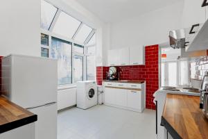 a kitchen with white appliances and a red brick wall at Staywhenever TS- 4 Bedroom House, King Size Beds, Sleeps 9 in Stoke on Trent