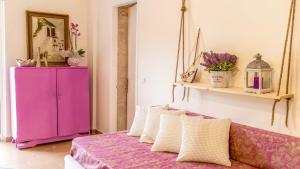 a bedroom with a pink cabinet and a purple couch at Villazia Exclusive Estate in Episkopianá