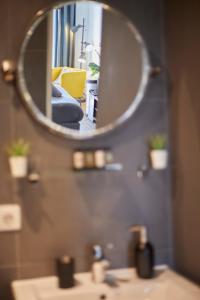 a mirror over a bathroom sink with a yellow chair at Modern Hideout Ace Location in Amsterdam