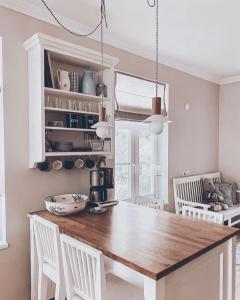 cocina con mesa de madera y sillas blancas en Linnuse Apartement, en Haapsalu