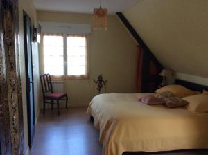 a bedroom with a bed and a window and a chair at L Entre deux in Champcey