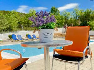 Villazia Exclusive Estate في Episkopianá: طاولة عليها وعاء من الزهور بجوار حمام سباحة