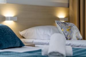 Pokój z łóżkiem z białą pościelą i poduszkami w obiekcie Akwamaryn w Grzybowie