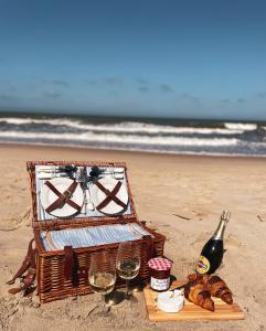 ein Picknickkorb am Strand mit Wein und Brot in der Unterkunft White Beach 211 in Mielno
