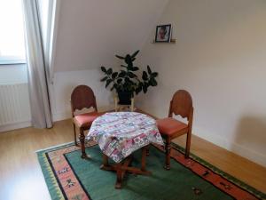 a dining room with a table and two chairs and a plant at Jacky's place in Helmond