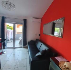 sala de estar con sofá y pared roja en Apartman Noa, en Jadrija