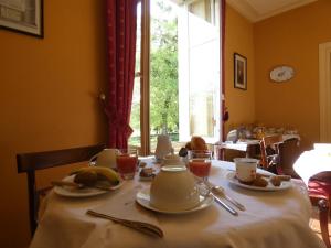 una mesa con hervidor de agua y platos de comida en Hôtel des 4 continents - Le Mans, en Saint-Saturnin