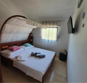 een kleine slaapkamer met een hemelbed bij Apartman Noa in Jadrija