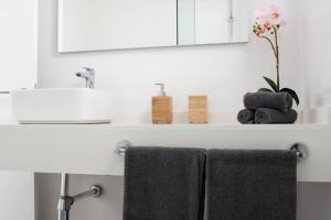 umywalkę z 2 ręcznikami i lustrem w obiekcie Apartamento Aguaviva, tu lugar al lado del Océano w Costa Teguise