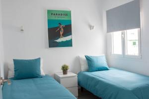 dwa łóżka ustawione obok siebie w pokoju w obiekcie Apartamento Aguaviva, tu lugar al lado del Océano w Costa Teguise +15 zdjęć