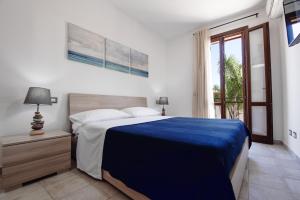 a bedroom with a large bed with a blue blanket at Sea Vito Apartment in San Vito lo Capo