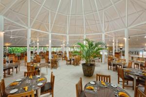 a restaurant with tables and chairs and a large tent at Embudu Village Resort in South Male Atoll