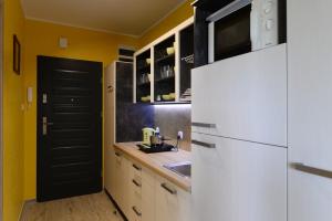 kuchnia z żółtymi ścianami i białą lodówką w obiekcie APARTAMENT JAN-53 Krynica Morska w mieście Krynica Morska