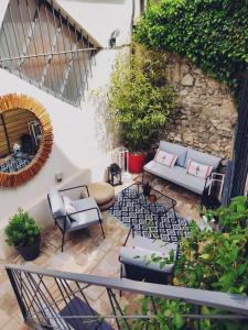 une terrasse avec un canapé, des chaises et des plantes dans l'établissement La Maison Grivolas Appartements et Maison d'hôtes, à Avignon