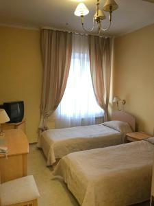 a hotel room with two beds and a window at Готель Ягодин in Starovoitove