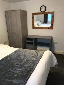 a bedroom with a bed and a mirror at 2 bedroom apartment in Plymouth