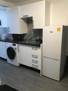普里茅斯的住宿－2 bedroom apartment，厨房配有白色橱柜、水槽和洗碗机。