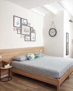 1 dormitorio con 1 cama y reloj en la pared en Panta Rei, en Alghero