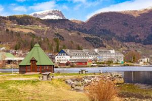 a town with a lake and mountains in the background at Ulvik Camping in Ulvik
